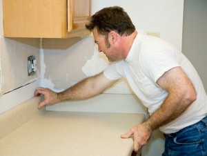 Contractor installing a laminate counter top during a kitchen remodel project.